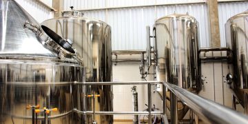 A view of stainless steel tanks in a modern brewery, showcasing industrial machinery and production equipment.