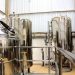 A view of stainless steel tanks in a modern brewery, showcasing industrial machinery and production equipment.
