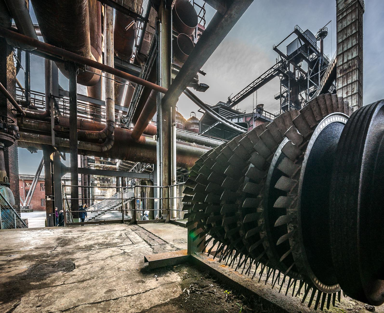 Detailed view of large industrial machinery in a factory with steel structures and pipes.