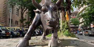 A prominent bull statue amidst a bustling urban street scene showcasing art and architecture.