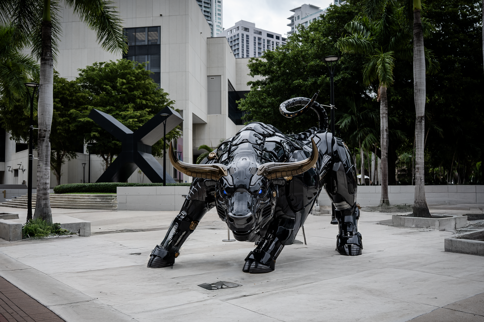 A striking bull sculpture in Miami surrounded by modern architecture and lush greenery.