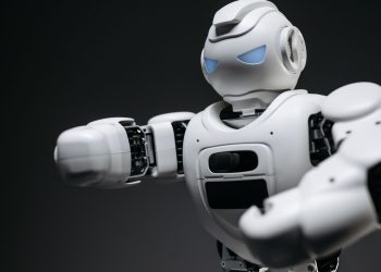 Detailed close-up of a high-tech white robot in a studio setting with a gray background.