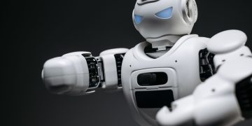 Detailed close-up of a high-tech white robot in a studio setting with a gray background.