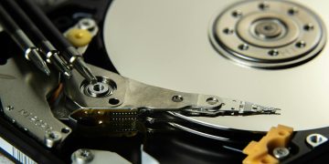Detailed view of internal hard drive platters and read/write heads for data storage technology.