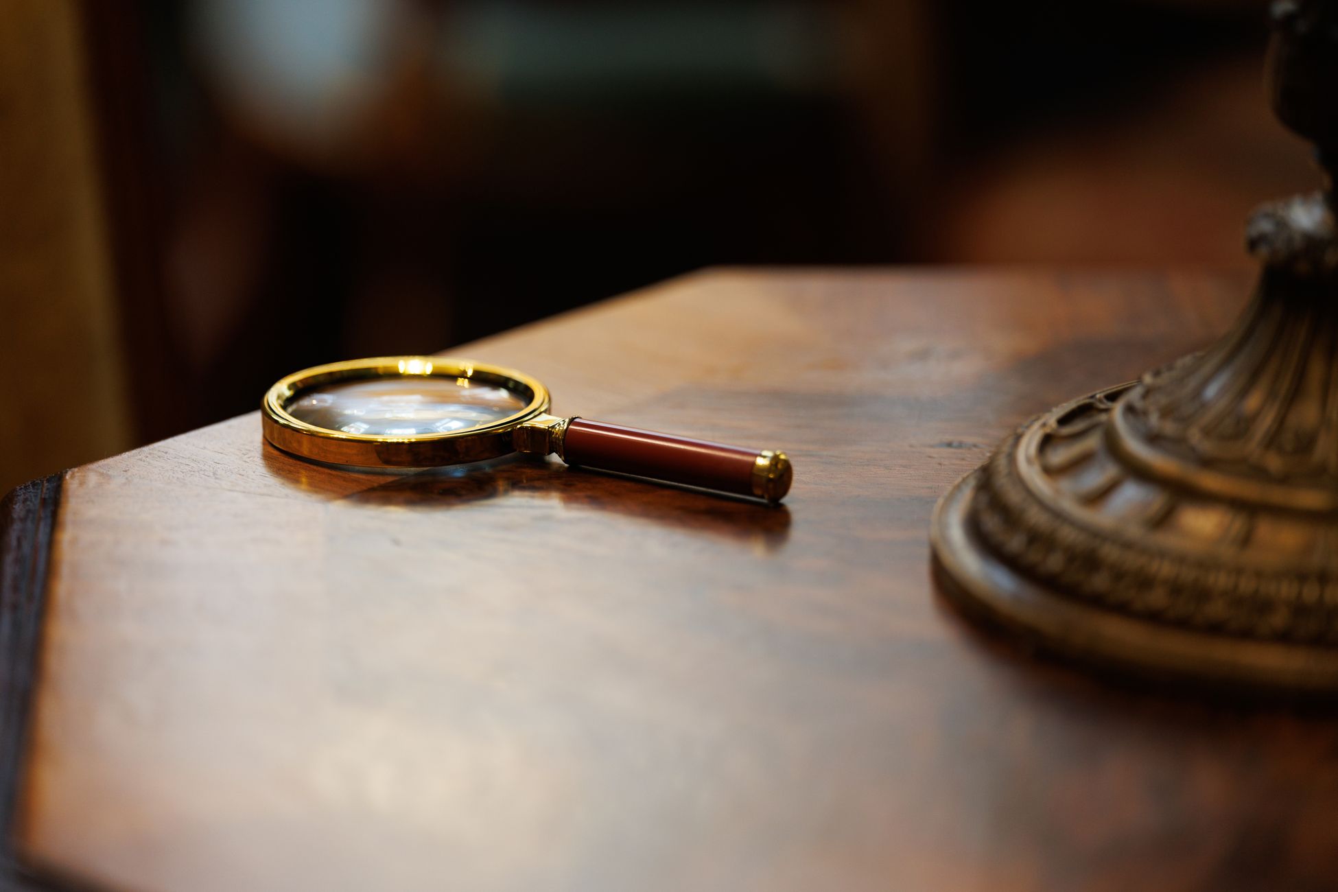 A vintage-style magnifying glass placed on a polished wooden table, exuding an elegant and classic look.