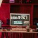 A professional video editing workspace featuring monitors, keyboard, and microphones in a studio setting.