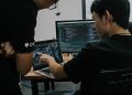 two men working on computers in an office