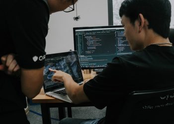 two men working on computers in an office
