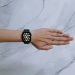 Overhead view of a smartwatch on an arm against a marble background representing modern technology.