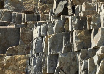 Close-up of a textured stone rock formation, showcasing natural geological structures.