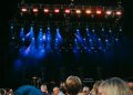 Night concert scene with audience, stage, and colorful lighting effects.