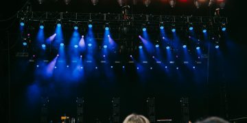 Night concert scene with audience, stage, and colorful lighting effects.
