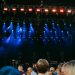Night concert scene with audience, stage, and colorful lighting effects.