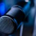 Detailed close-up of a professional studio microphone with a blurred blue background.