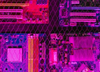 Colorful circuit boards behind a wire mesh, enhanced with pink and purple hues.
