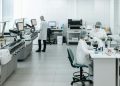 Researchers in lab coats performing experiments with advanced equipment in a laboratory.