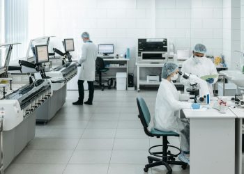 Researchers in lab coats performing experiments with advanced equipment in a laboratory.
