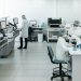 Researchers in lab coats performing experiments with advanced equipment in a laboratory.