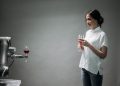 A robot presents a glass of wine to a woman, showcasing modern technology and interaction.