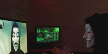 Masked individual in dark room interacting with computer screens displaying hacker imagery and code.