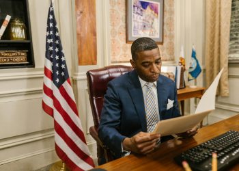 A professional man in a law office reads a document, symbolizing focus and diligence.