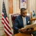 A professional man in a law office reads a document, symbolizing focus and diligence.