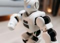 Close-up of a futuristic toy robot with blue eyes, showcasing modern technology indoors.
