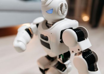Close-up of a futuristic toy robot with blue eyes, showcasing modern technology indoors.