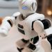 Close-up of a futuristic toy robot with blue eyes, showcasing modern technology indoors.