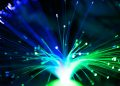 Close-up of illuminated fiber optic lights in blue and green colors, showcasing modern technology.