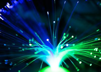 Close-up of illuminated fiber optic lights in blue and green colors, showcasing modern technology.