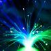 Close-up of illuminated fiber optic lights in blue and green colors, showcasing modern technology.