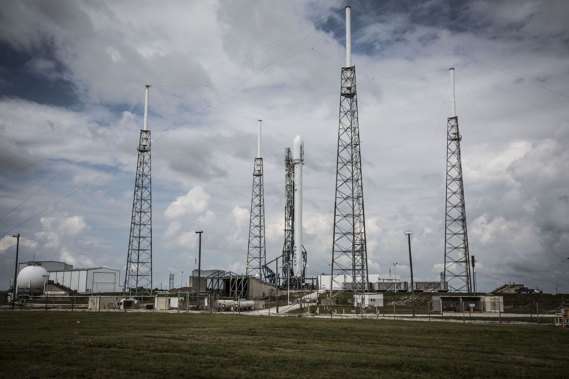 Industrial rocket launch pad with tall towers under a cloudy sky, perfect for technology and energy themes.