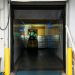A forklift unloading goods at an industrial loading dock inside a warehouse.