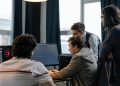 Group of developers working together on a computer programming project indoors.