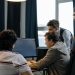 Group of developers working together on a computer programming project indoors.