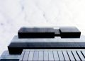 Contemporary building with a glass facade and geometric patterns, low angle view.