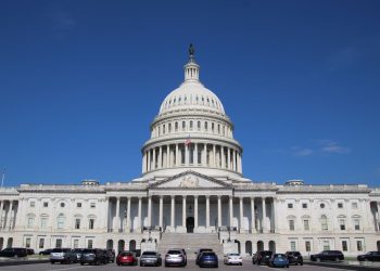 A striking image of the United States Capitol Building under a clear blue sky, symbolizing American democracy.
