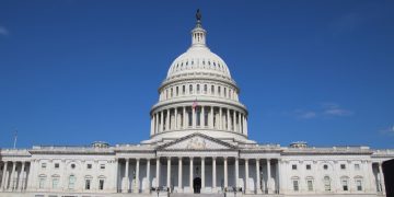 A striking image of the United States Capitol Building under a clear blue sky, symbolizing American democracy.