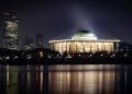 Stunning cityscape featuring a well-lit domed building and skyline at night.