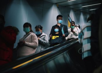 People wearing masks on an escalator in Shanghai during pandemic times.