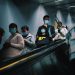 People wearing masks on an escalator in Shanghai during pandemic times.
