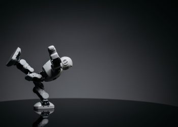 Minimalist photo of a toy robot balancing creatively in a studio setting.
