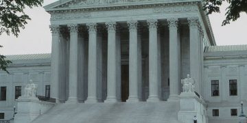 Front view of the iconic Supreme Court building with classical columns and majestic architecture.