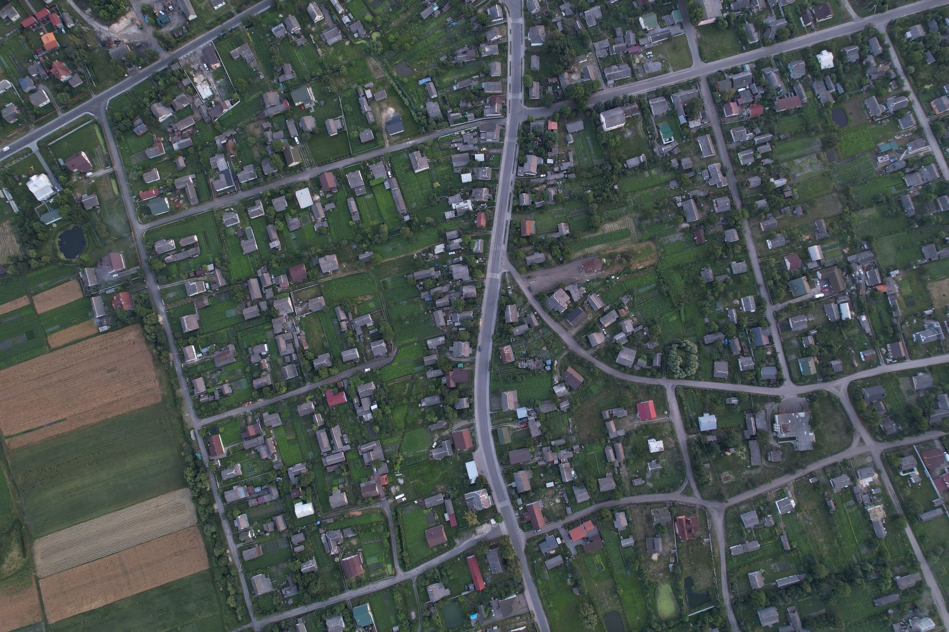 Aerial photo of a residential neighborhood in Shats'k, Ukraine, showcasing green spaces and homes.