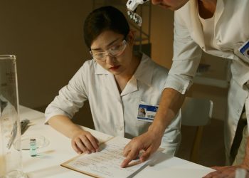 Researchers in lab coats analyzing experimental notes during a scientific study.