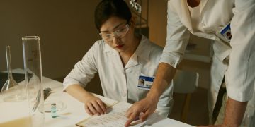 Researchers in lab coats analyzing experimental notes during a scientific study.