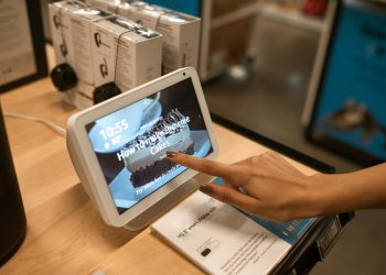 Close-up of a hand using a smart display showing a recipe for brownie cakes in a store setting.