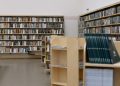 Spacious university library featuring wooden bookshelves filled with diverse books for education and research.