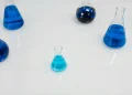 Various glass flasks filled with blue liquid in a scientific setting, perfect for research themes.